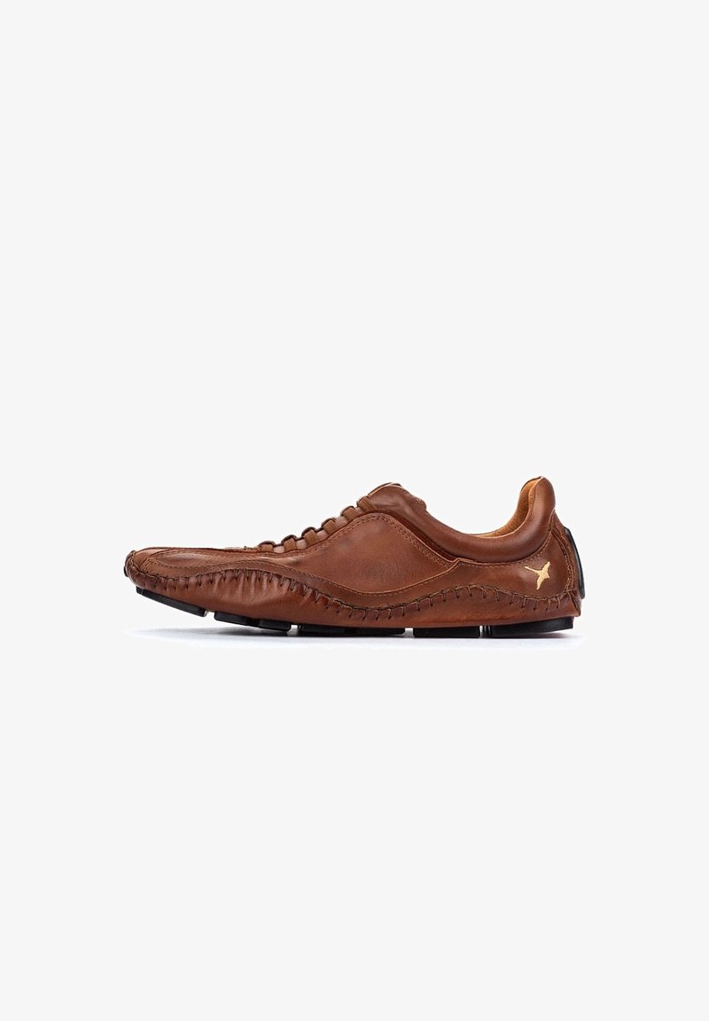 Chaussure décontractée en cuir marron avec des détails cousus à la main, semelle profil basse et un petit logo oiseau doré près du talon sur un fond blanc.