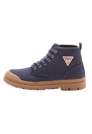 Zapatilla deportiva de caña alta azul marino con suela de goma marrón, puntera, ojales metálicos, cordones y un logo triangular de Guess en el lateral.