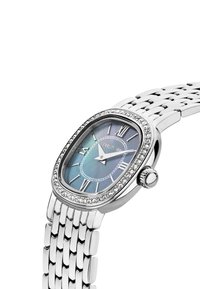 Silver oval watch with a blue iridescent dial, Roman numerals, and crystal accents. Features a metal mesh bracelet design.