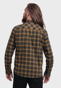 Gestreifte Flanellhemd in Schwarz und Senfgelb. Lange Ärmel, Knopfmanschetten und abgerundeter Saum. Rückansicht mit Detail der Schulterpasse.