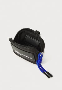 Svart dragkedjepåse tillverkad av slitstarkt tyg med en texturerad yttermaterial, med en blå snoddaccent och en slät svart kortficka inuti.