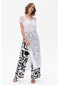 Witte opengehaakte top met korte mouwen, gecombineerd met zwart-witte zebra-print wijde broek. Glad textuur en losse pasvorm. Bruine sandalen.