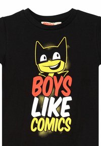 Sort bomulds t-shirt med en gul tegneseriefigur med et katteagtigt ansigt og fed tekst, der står "BOYS LIKE COMICS" i rød, hvid og gul.