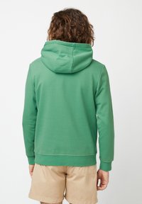 Green hoodie made of soft fabric, featuring a drawstring hood, ribbed cuffs, and hem, with a smooth texture and minimalist design.