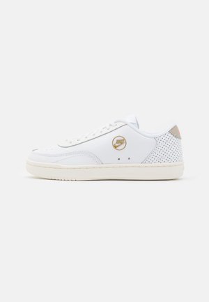 Baskets blanches avec empeigne en cuir, finition lisse et accents perforés. Comprend des lacets plats, une languette rembourrée et un détail de logo doré.