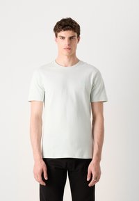 T-shirt curto de manga curta em verde menta pálido, feito de algodão suave, com um discreto logótipo da marca no peito e um clássico decote redondo.