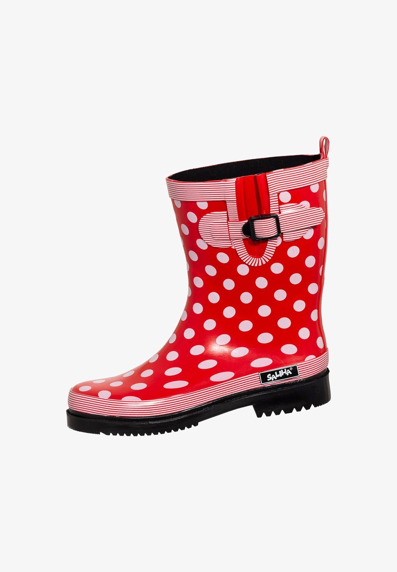 Red rubber rain boot with large white polka dots, black traction sole, striped cuff, and decorative buckle detail at the top.