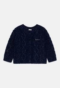 Marineblå strikket cardigan med flettestrikkmønster, rund hals, lange ermer, og fem svarte knapper foran. Liten brodert tekst.
