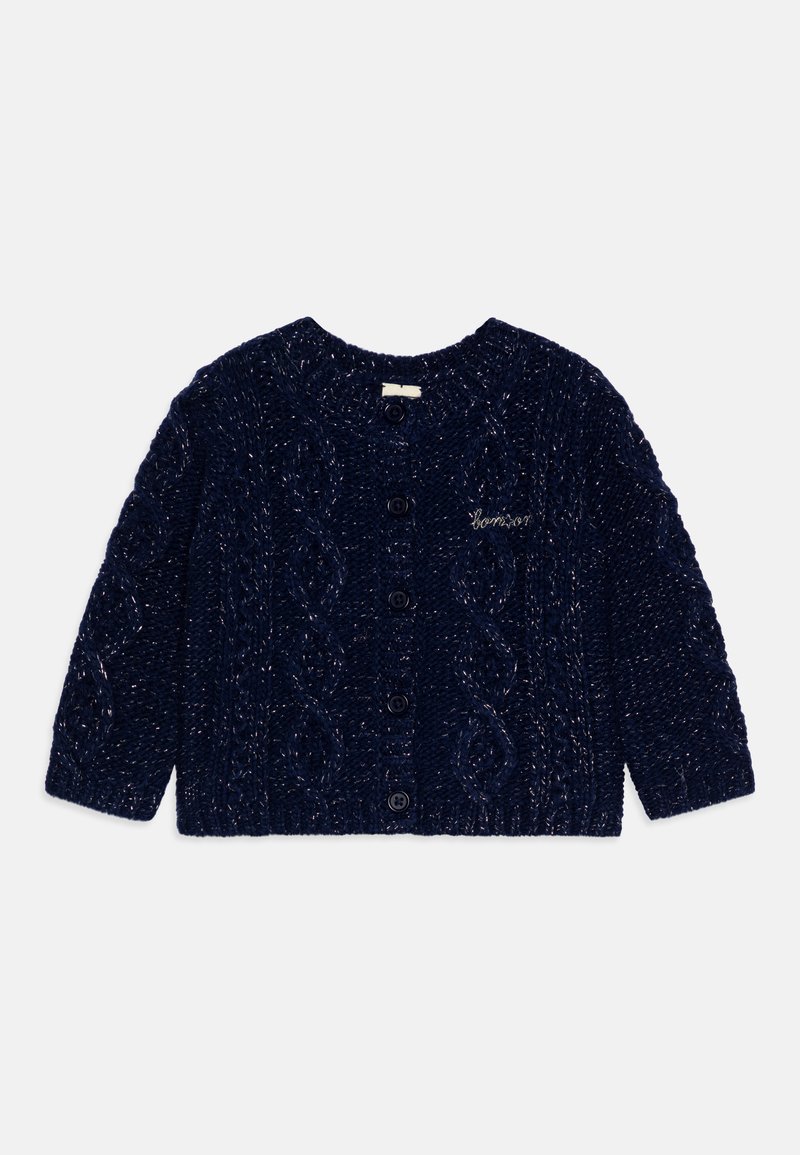Marineblå strikket cardigan med flettestrikkmønster, rund hals, lange ermer, og fem svarte knapper foran. Liten brodert tekst.