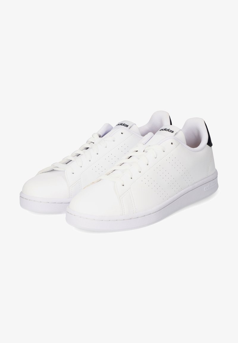 Zapatillas deportivas de piel blanca con una textura suave, detalles perforados en los laterales, suela plana de goma blanca y lengüeta del talón en azul oscuro.
