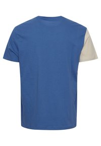 T-shirt bleu à manches courtes avec une manche beige unique, vu de dos, avec un col rond et un design simple.