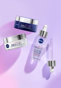 Three Nivea skincare products: a dark blue night cream, a white day cream with SPF, and a clear serum with a silver dropper, all on a gradient background.