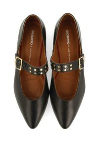 Chaussures en cuir noir avec un bout pointu, présentant une sangle en cuir texturé noir et une boucle en or avec des clous décoratifs. Intérieur marron avec logo.