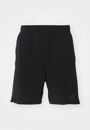 Shorts de sport noirs en tissu léger avec une taille élastique. Comprend des fentes sur les côtés et un accent logo subtil sur la jambe gauche.