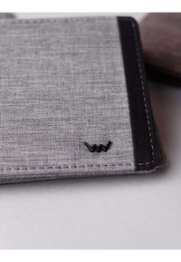Grey fabric wallet with black accents and stitching, featuring a minimalistic logo on the front. Smooth texture and rectangular shape.