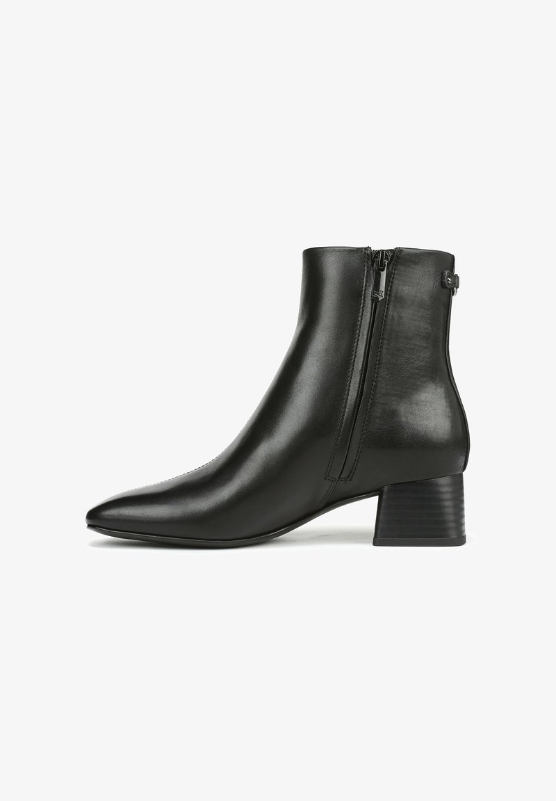 Bottes en cuir noir à talon bas, avec un bout pointu, une texture lisse, une fermeture éclair à l'arrière et des éléments de design minimalistes.