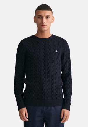Marine gebreid sweater met kabelontwerp, ronde hals en geribde manchetten en zoom. Geborduurd logo op de borst. Lichtgewicht stof.