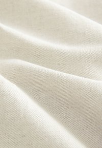 Cotton fabric in an off-white color with a smooth texture and fine, subtle stripes running diagonally across the surface.