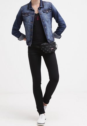 Jeansjacka, svart linne med tryck, svarta skinny jeans, svart midjeväska med vita prickar och vita sneakers.