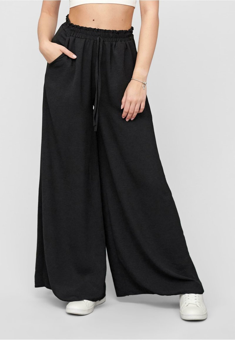 Black wide-leg pants made of soft fabric, featuring an elastic waistband with drawstring and side pockets. Simple design, casual fit.