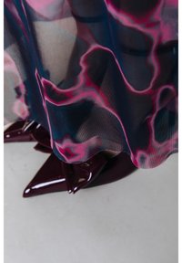 Escarpins à talons hauts pointus en cuir verni bordeaux foncé partiellement couverts d'un tissu transparent avec un motif abstrait rose et noir.