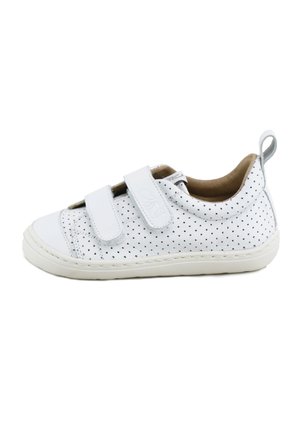 Zapatilla blanca para niños con puntos perforados negros, dos tiras de velcro, forro interior beige y una lengüeta en el talón.