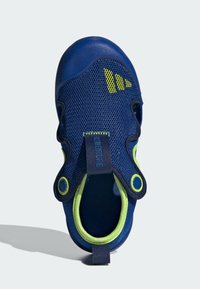 Navy blue hengittävät verkokengät vihreillä yksityiskohdilla, pyöreällä aukolla ja teksturoidulla kumipohjalla. Ominaisuuksiin kuuluu kaksi pyöreää rei'itystä ja hihna.