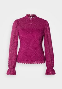 Blouse en dentelle magenta à manches longues avec motifs floraux, bords festonnés aux poignets et à l’ourlet, et col montant avec fermeture goutte d’eau au dos.