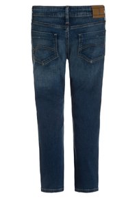 Tummansiniset farkut, joissa on suora leikkaus, takataskut ompeluyksityiskohdilla ja vaaleanruskea nahkapaikka vyötäröllä.