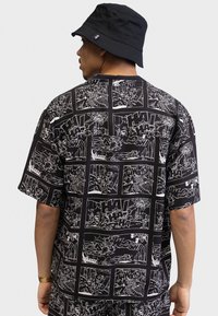 Short-sleeve black shirt featuring white comic panel designs, with scenes and sound effects. Smooth texture, loose fit.