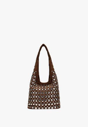 Bolso tote de ante marrón suave, con grandes remaches circulares plateados que cubren su superficie y un asa ancha y redondeada.