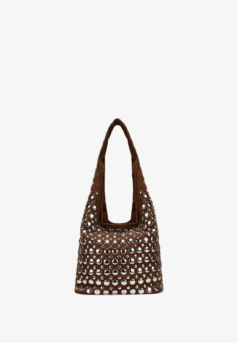 Bolso tote de ante marrón suave, con grandes remaches circulares plateados que cubren su superficie y un asa ancha y redondeada.