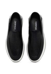 Black slip-on shoes with a textured leather upper and a white rubber sole. Features minimal branding and smooth stitching details.