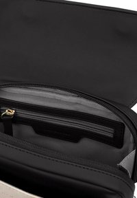 Czarny skórzany portfel o gładkiej fakturze, z komorą na zamek błyskawiczny i szarym wykończeniem z tkaniny. Wewnątrz znajdują się kieszenie na karty.