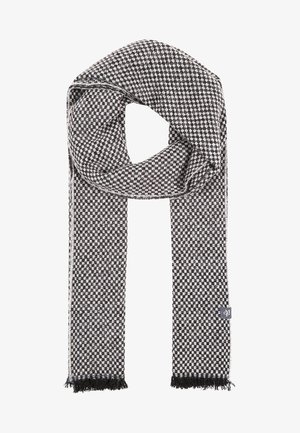 Écharpe en laine à carreaux noirs et blancs avec des extrémités à franges et une petite étiquette de marque rectangulaire sur un côté.