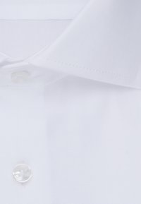 Witte shirt met een gestructureerde stof, knoopsluiting en een klassieke kraag. Heeft een ronde, doorzichtige knoop en nette stiksels.