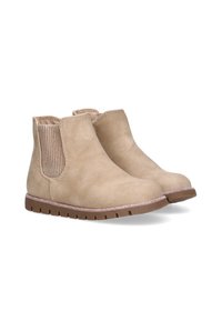 Botas de tobillo beige hechas de suave ante con paneles laterales elásticos y una suela de goma marrón texturizada. Sutiles acentos de brillo a lo largo de la suela.