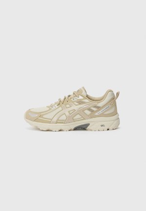 Chaussure de course beige et crème avec des empiècements en mesh et synthétiques, marquée GEL-Venture 8 sur le côté, et semelle épaisse avec amorti GEL.
