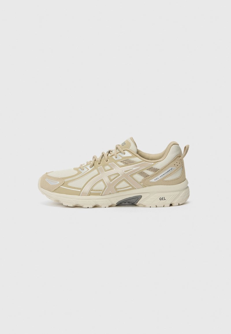 Chaussure de course beige et crème avec des empiècements en mesh et synthétiques, marquée GEL-Venture 8 sur le côté, et semelle épaisse avec amorti GEL.