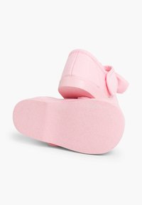 Pantof cu țesătură roz, cu talpă din cauciuc texturat și curea ajustabilă cu Velcro. Designul are un vârf rotund și margini moi și netede.