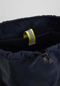 Borsa in tessuto nero con parte superiore arricciata, caratterizzata da un laccio giallo e grigio all'interno. Texture liscia senza motivi o loghi visibili.