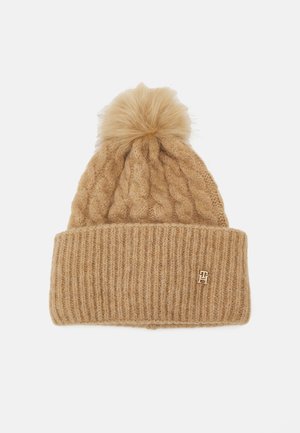 Berretto beige lavorato a maglia con risvolto a coste e pompon in pelliccia sintetica sulla parte superiore. Presenta un piccolo logo dorato sul risvolto.