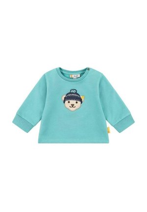 Turkusowy sweter z długim rękawem z wyhaftowaną na przodzie twarzą niedźwiedzia, ozdobiony wzorem niebieskiej dzierganej czapki.