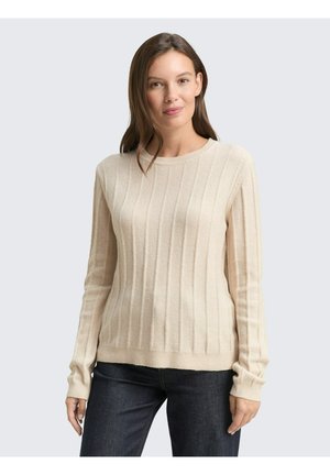 Beige Rippenstrickpullover mit langen Ärmeln und Rundhalsausschnitt. Weiche Textur mit lockerer Passform. Kombiniert mit dunklen Jeans.