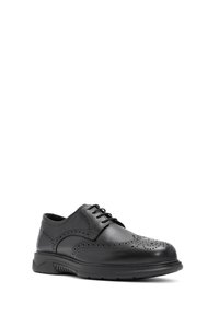 Chaussure de ville en cuir noir avec design à bout d'aigle, accents perforés, fermeture à lacets et semelle en caoutchouc pour flexibilité et confort.