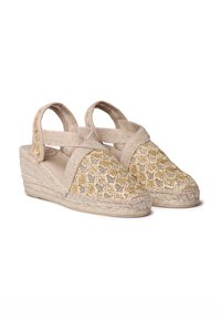 Sandalias de esparto beige con correas cruzadas, parte superior texturizada de tejido en dorado claro y fibras naturales, y un tacón de cuña envuelto en yute.