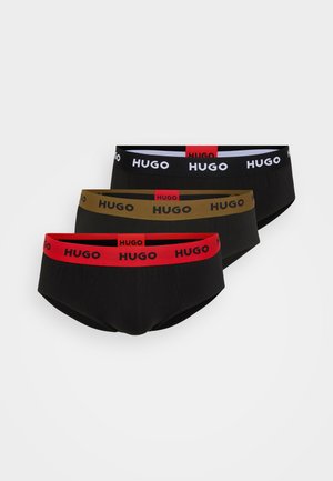Drei Paar Herrenunterwäsche aus schwarzem, olivgrünem und rotem Stoff, jeweils mit kontrastierenden elastischen Taillenbändern, die mit "HUGO" beschriftet sind.