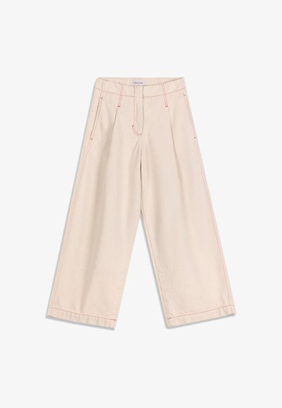 Pantalon beige à jambes larges avec coutures rouges, poches avant et ceinture avec passants, posé à plat sur un fond blanc.