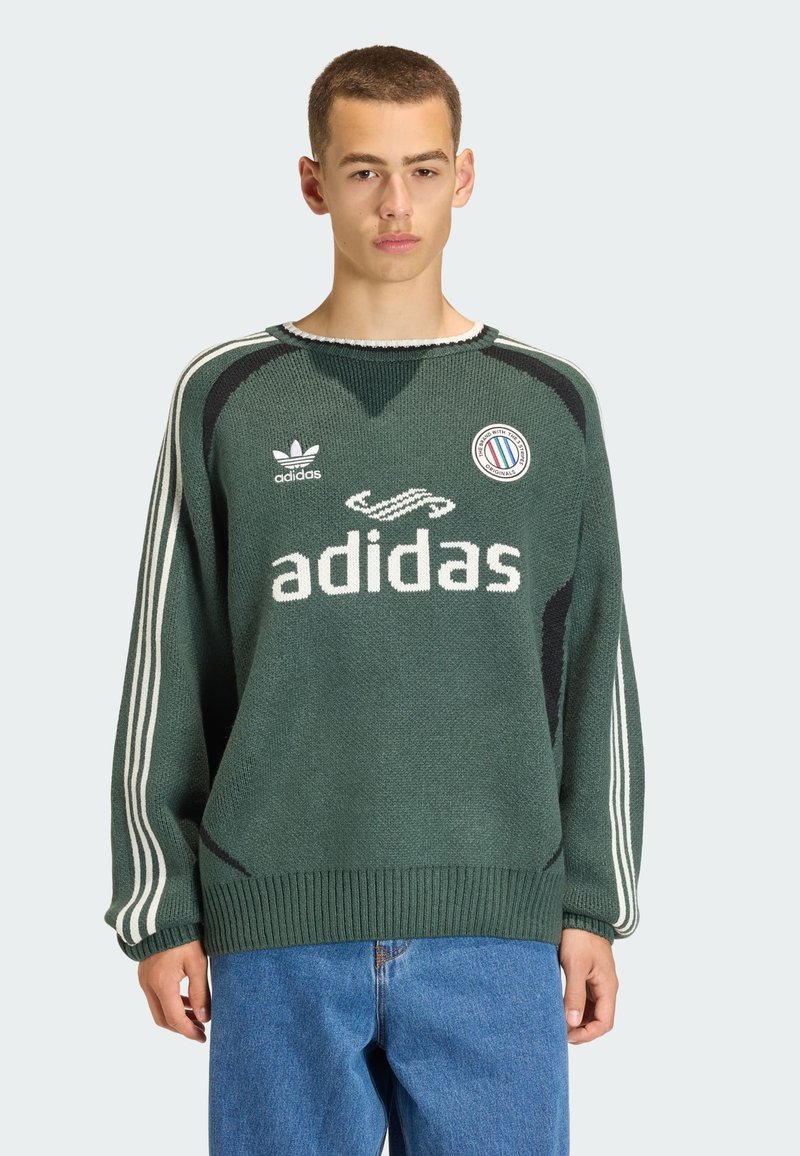 Maglione verde lavorato a maglia con accenti bianchi e neri, con scollo rotondo, orlo a coste e righe laterali. Il logo Adidas è ben visibile.