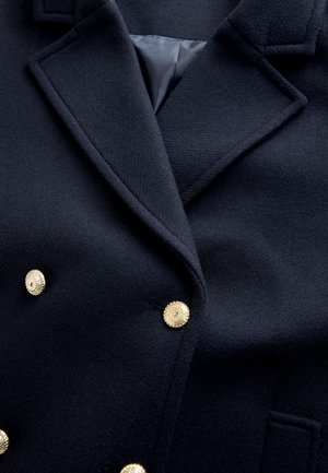 Marineblauwe wollen blazer met goudkleurige knopen, een bladkraag met inkeping en twee klepzakken aan de voorkant. Gestructureerde stof met een gladde binnenvoering.